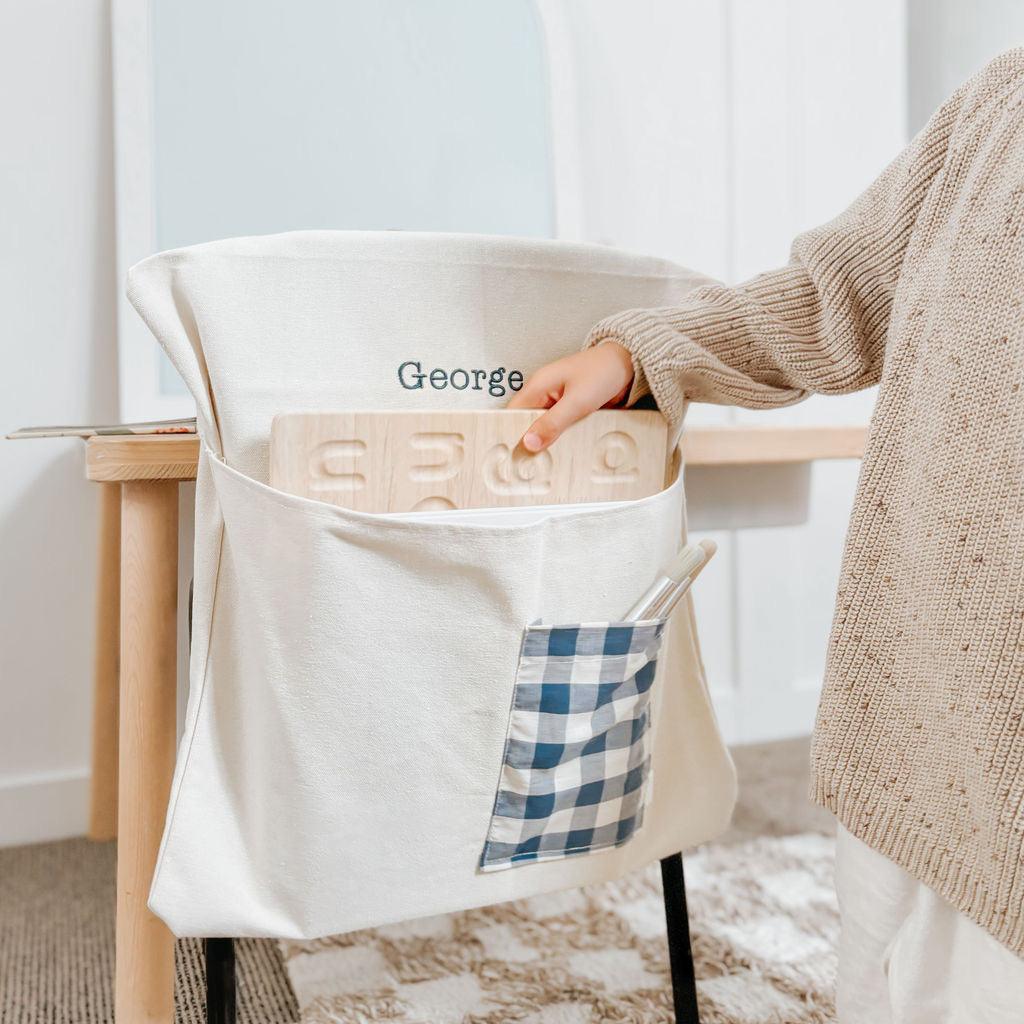 Personalised chair bag with gingham pocket, embroidered name, and sturdy canvas material.
