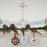 Personalised initials ornament set with festive designs hanging on garland above fireplace mantel