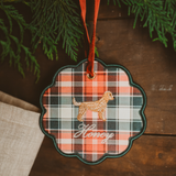 Personalised pet ornament featuring a plaid pattern and embroidered dog design with name "Honey" hanging on a red ribbon in holiday decor setting