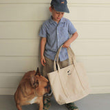 Child holding personalised heavyweight canvas tote bag with dog nearby