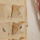 Personalized embroidered advent calendar with vintage cross stitch designs on cotton canvas pockets