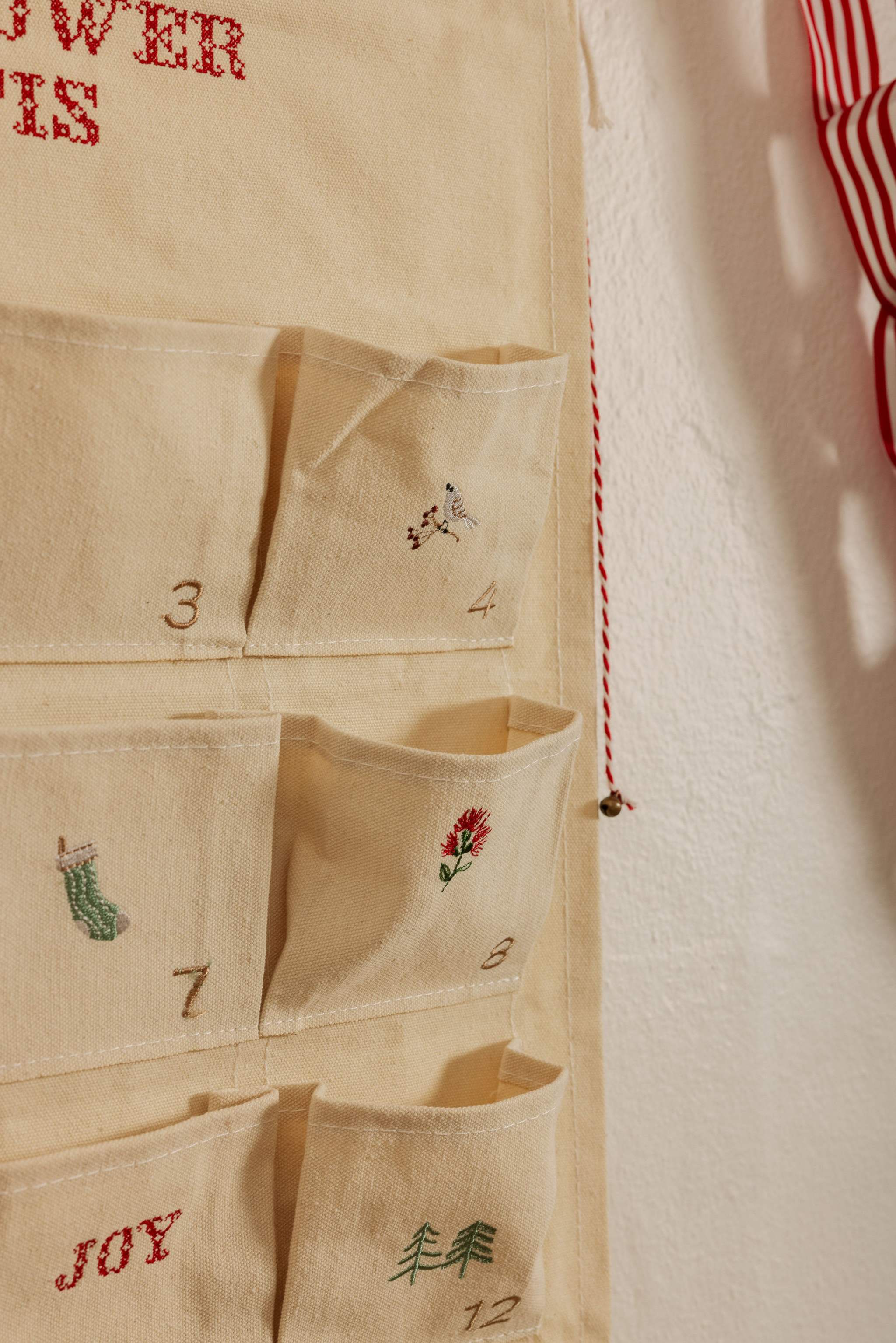 Personalized embroidered advent calendar with vintage cross stitch designs on cotton canvas pockets