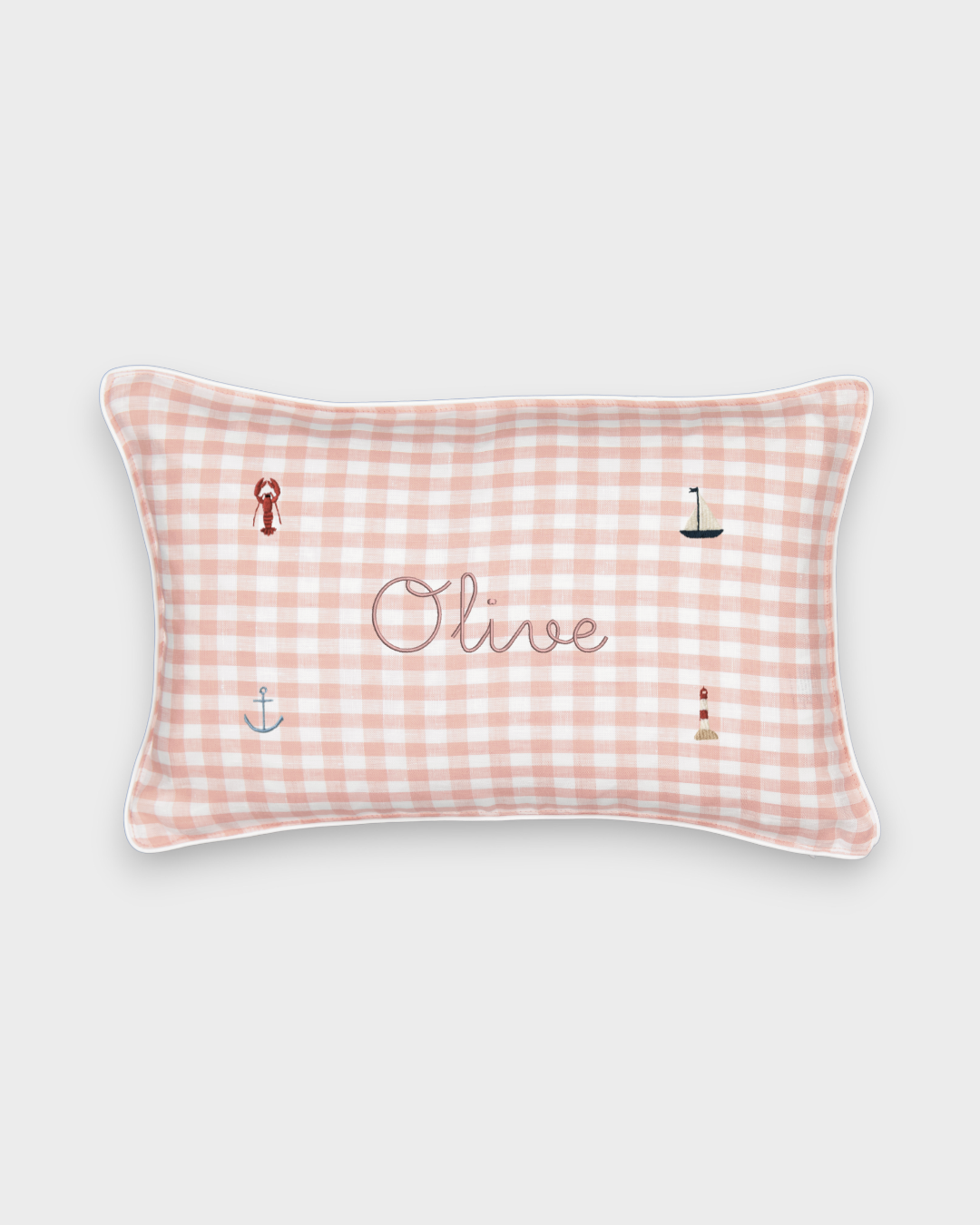 Nautical cushion with pink gingham linen, embroidered sea-themed designs, and personalized name "Olive"