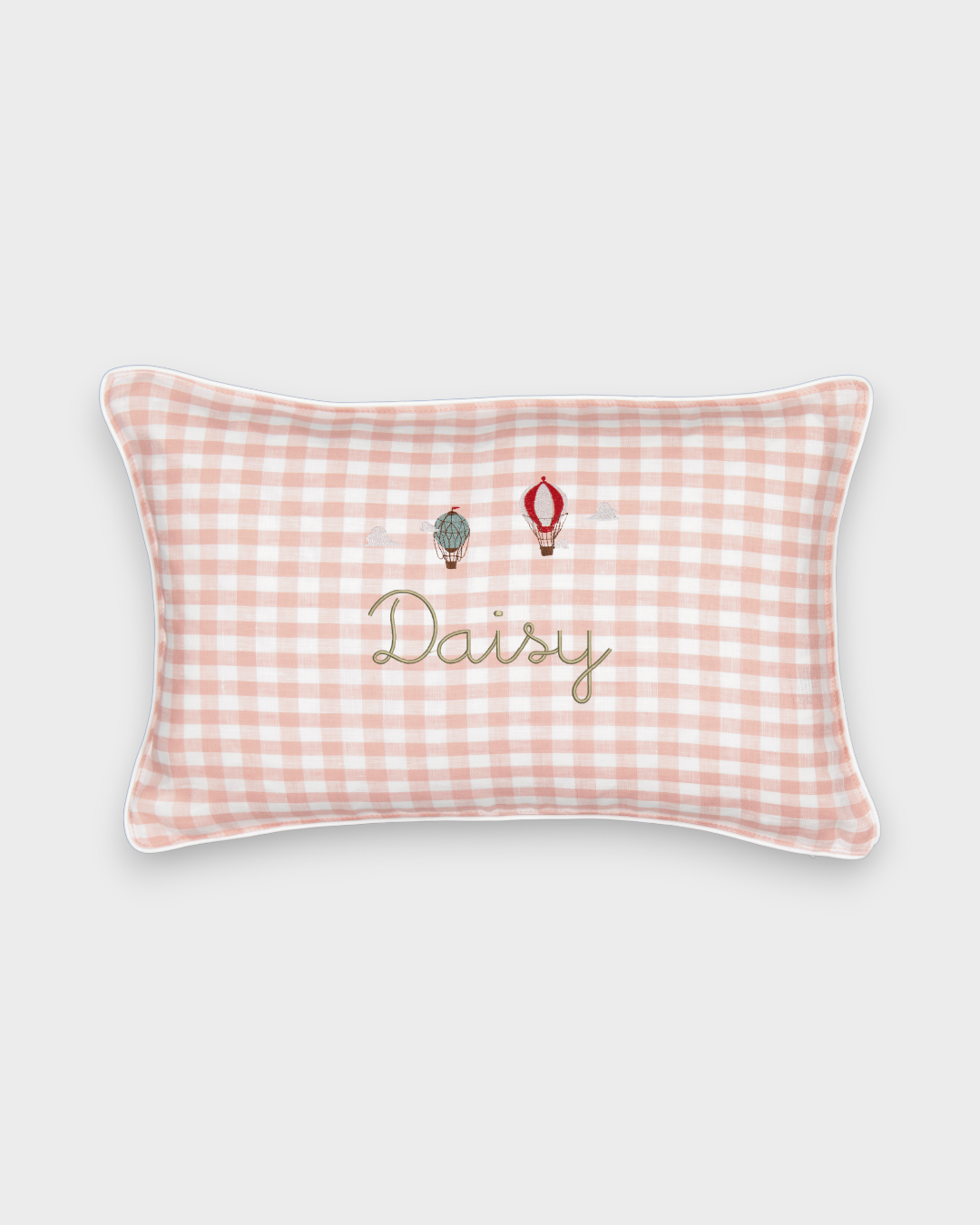 Pink gingham linen cushion with embroidered hot air balloons and personalized name "Daisy"