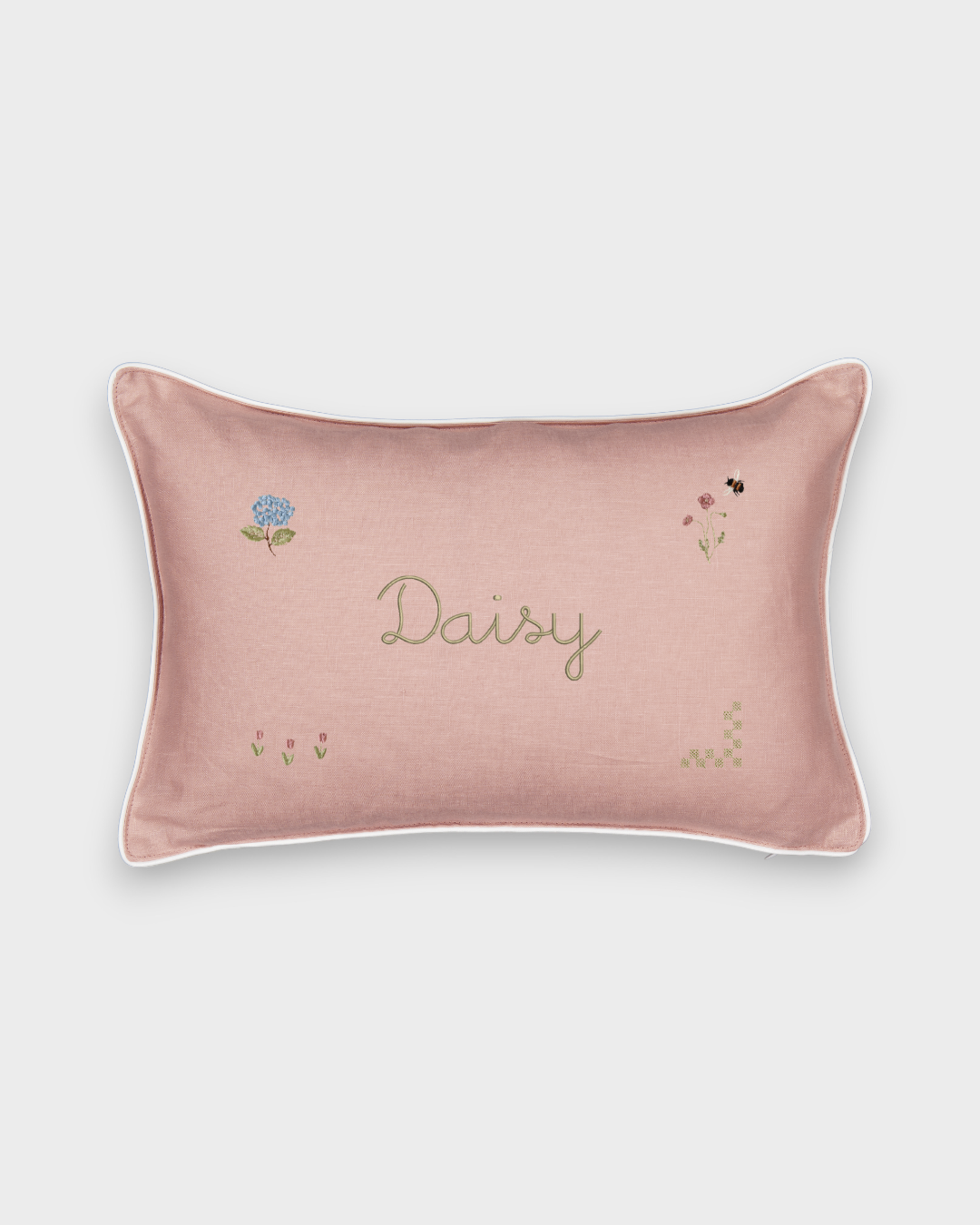 Pink botanical linen cushion with embroidered floral designs and personalized name "Daisy"