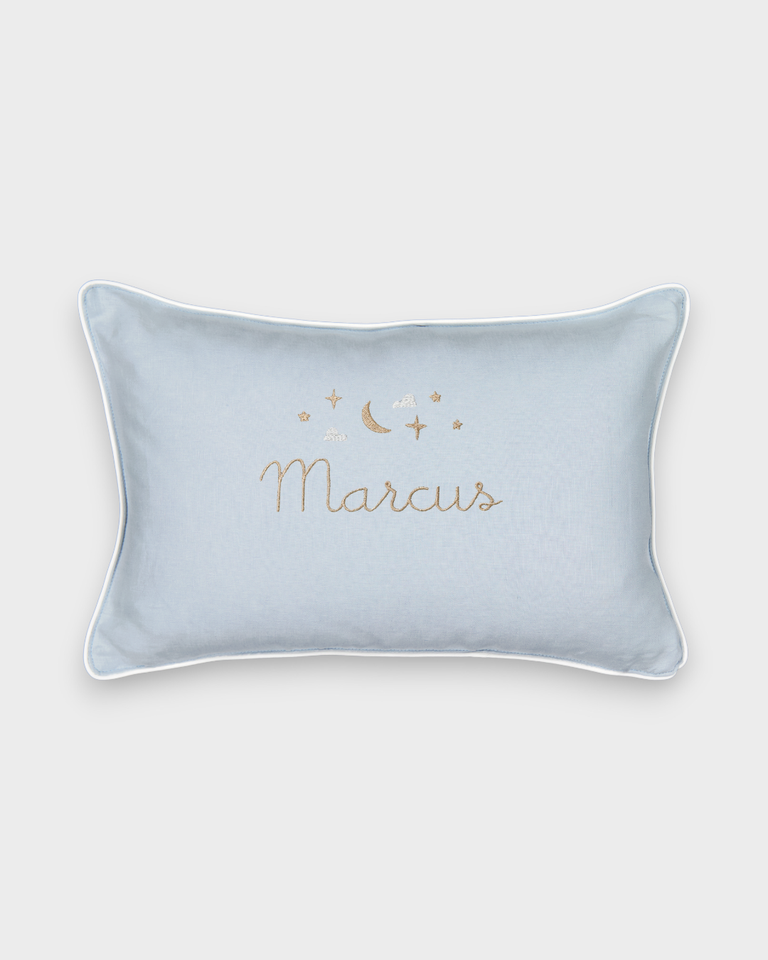 Light blue Moon and Stars Cushion with embroidered moon, stars, and personalized name, featuring white piping and natural linen back.