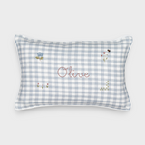Botanical linen cushion with blue gingham pattern, hand-drawn floral embroidery, and personalized name "Olive" on front