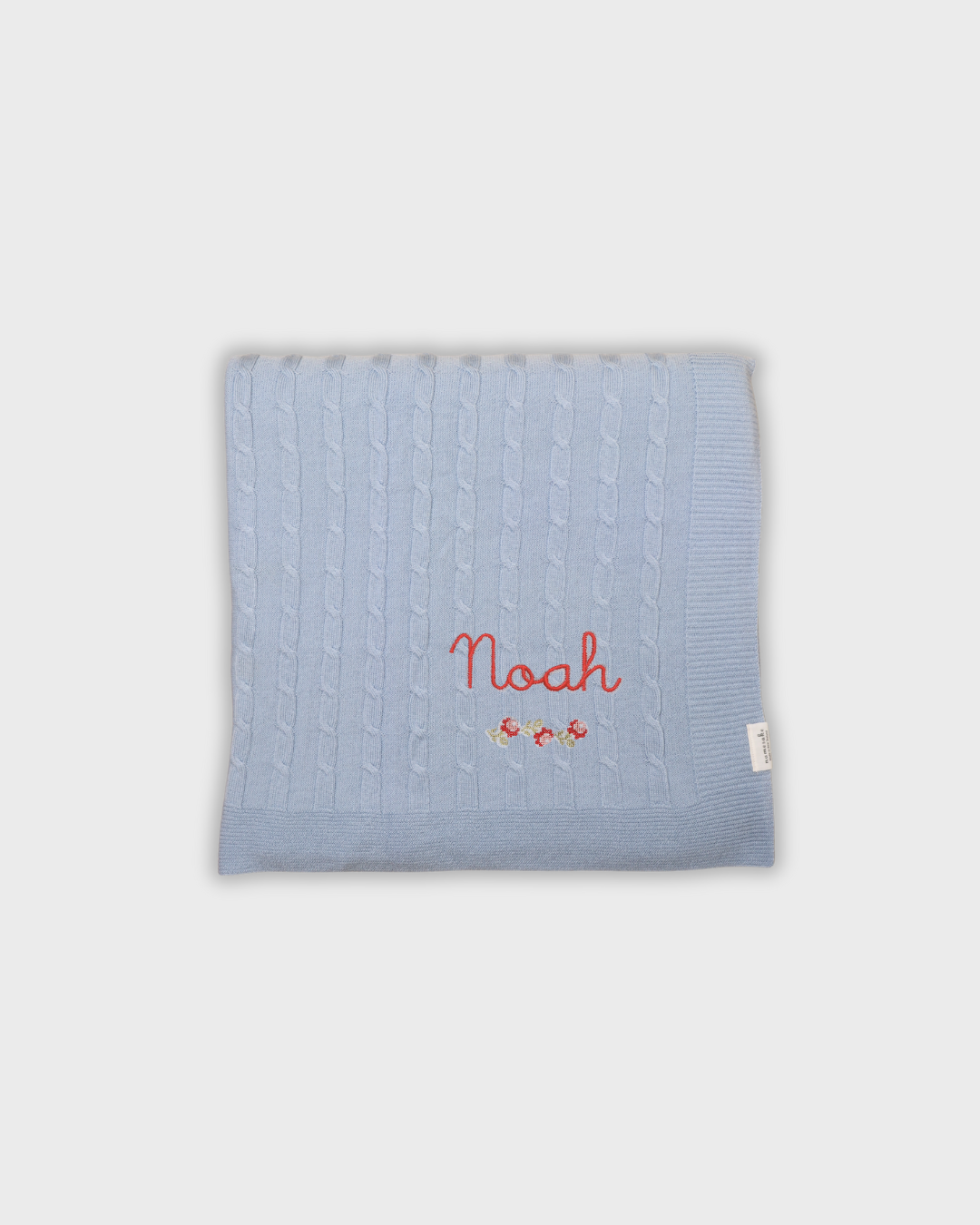 Blue merino baby blanket with personalized embroidery and rosette design