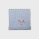 Blue merino baby blanket with personalized embroidery and rosette design