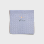 Soft blue Merino baby blanket with embroidered moon and stars design and personalized name Charlie.