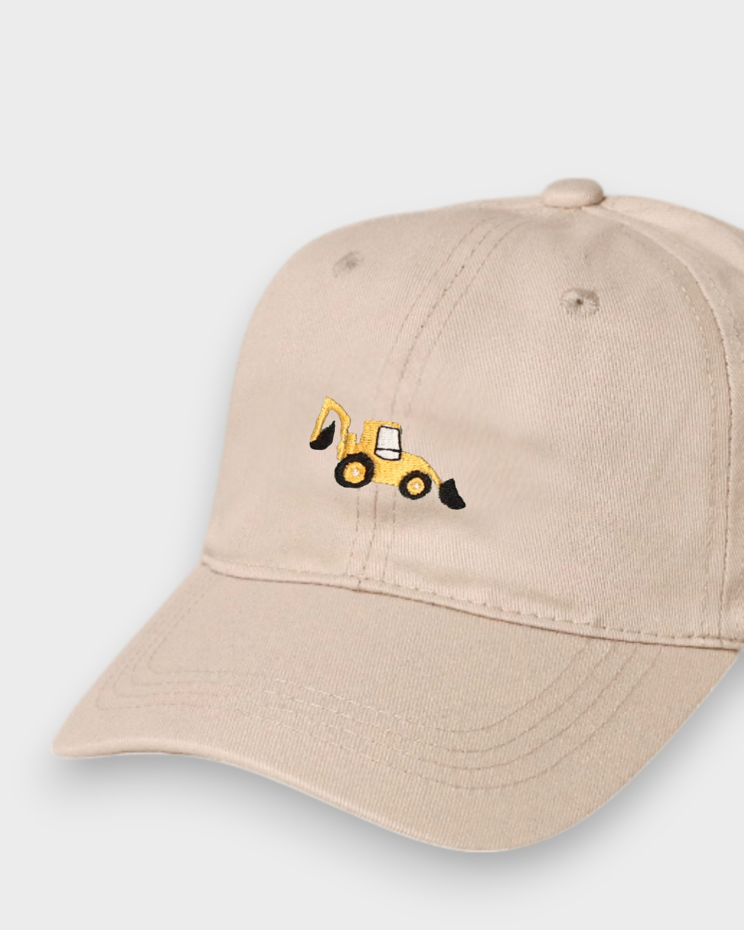 Beige personalised hat with embroidered yellow digger design on front, made of 100% washed cotton in classic baseball style