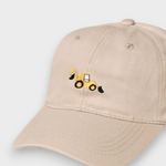 Beige personalised hat with embroidered yellow digger design on front, made of 100% washed cotton in classic baseball style