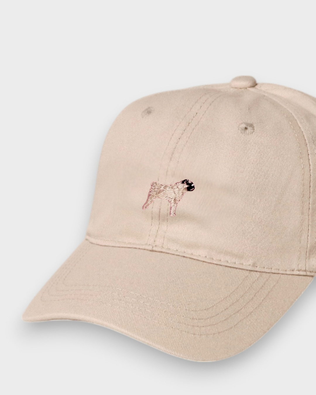 Beige Pug Personalised Hat with hand-drawn embroidered pug design on front, made of 100% washed cotton in classic baseball style.