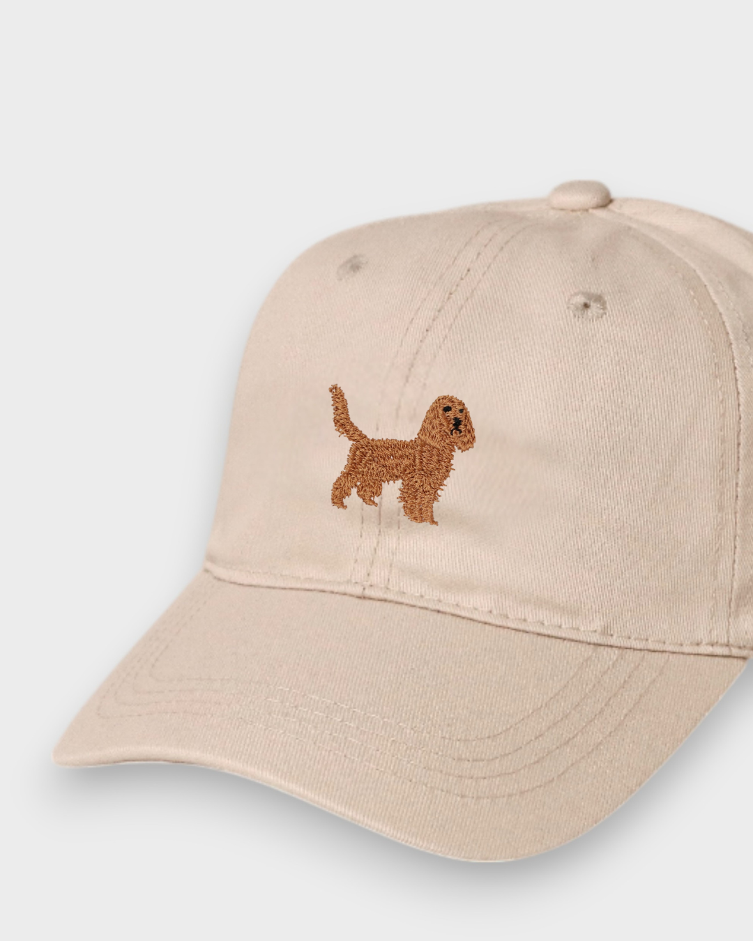 Beige baseball cap with embroidered brown Cocker Spaniel design on the front, personalised embroidery option on the back, made of 100% washed cotton.