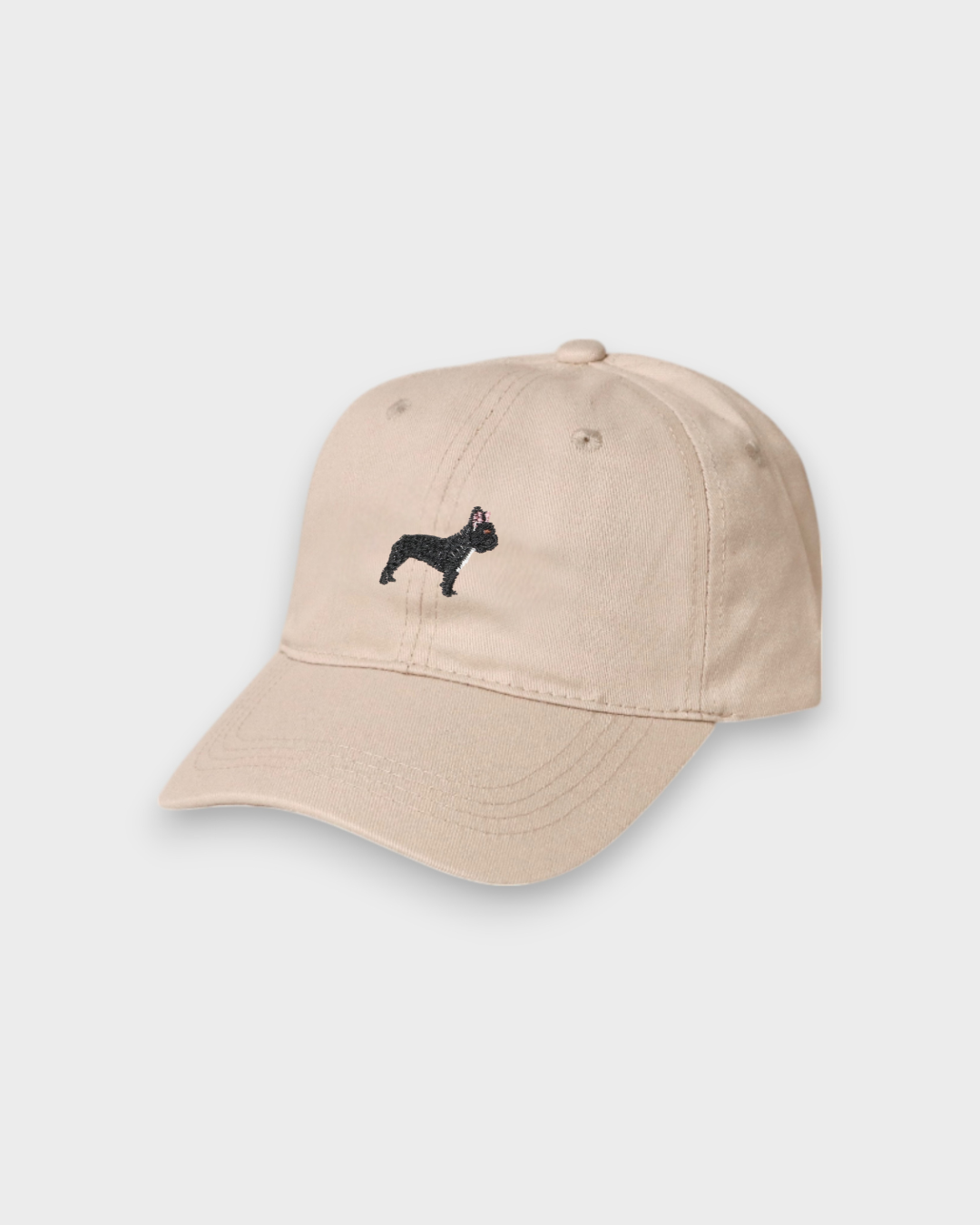 Beige baseball cap with embroidered black French Bulldog design and customizable back embroidery, made of 100% washed cotton.