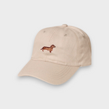 Beige personalised hat with hand-embroidered brown Dachshund design on front, made of 100% washed cotton in classic baseball style.