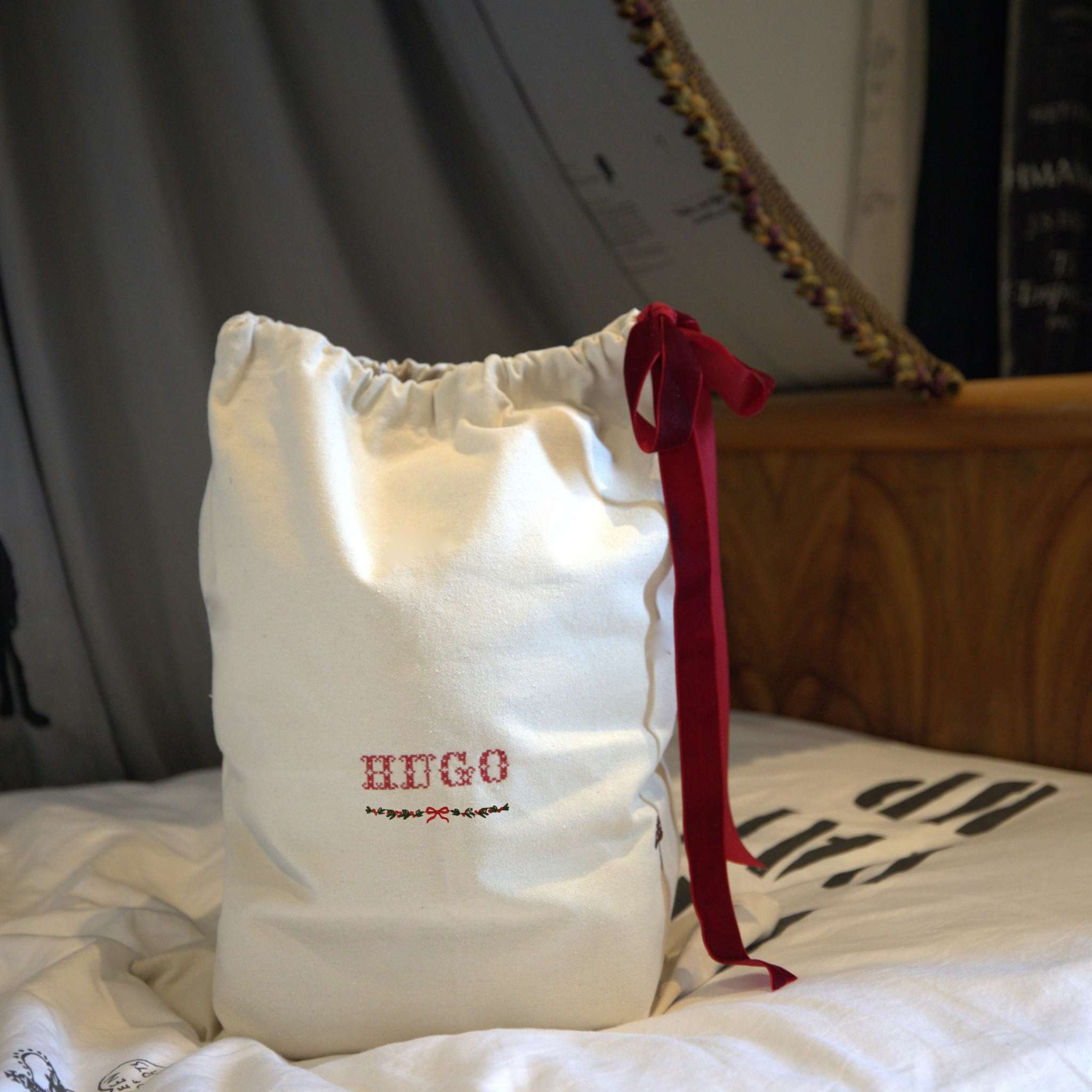 Personalized cotton canvas Santa Sack with burgundy velvet tie and festive hand-drawn garland embroidery
