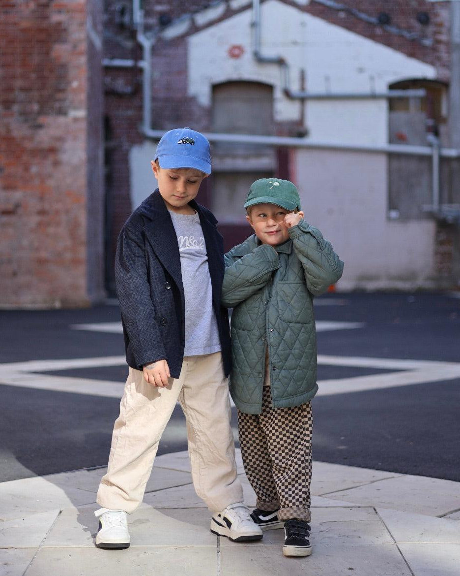Children wearing personalised tennis hats with embroidery designs.