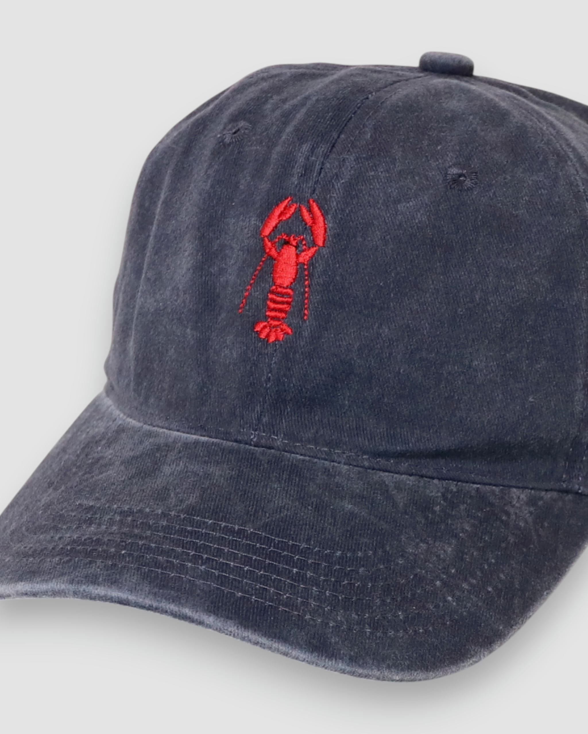 Navy blue baseball cap with red lobster embroidery on front, personalised hat design.