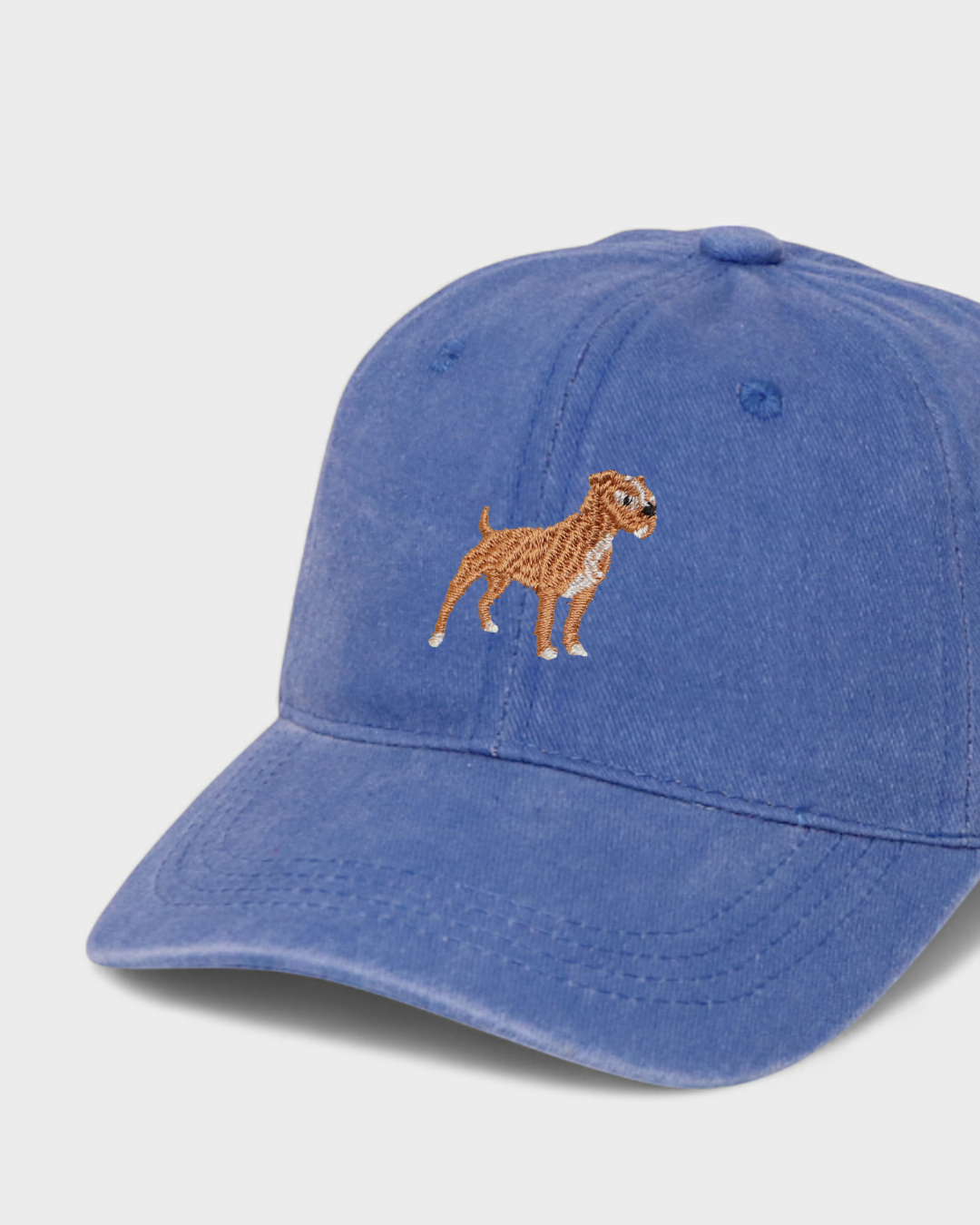Blue baseball hat with embroidered Staffordshire Bull Terrier design on the front, made from 100% washed cotton.