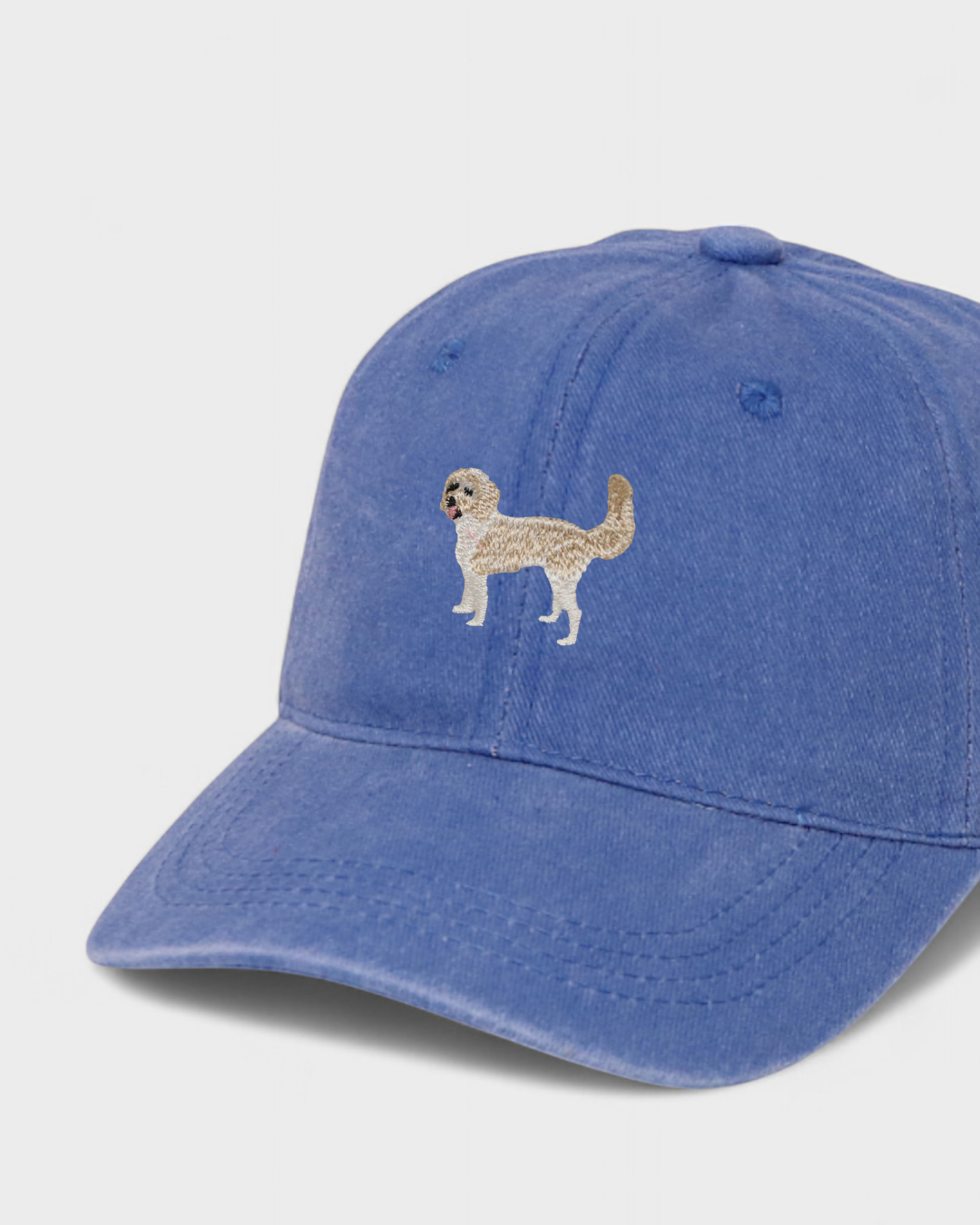 Blue baseball cap with hand-embroidered Sheepadoodle design and personalized embroidery option, 100% washed cotton.
