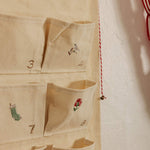 Personalized embroidered advent calendar with vintage cross stitch designs on cotton canvas pockets