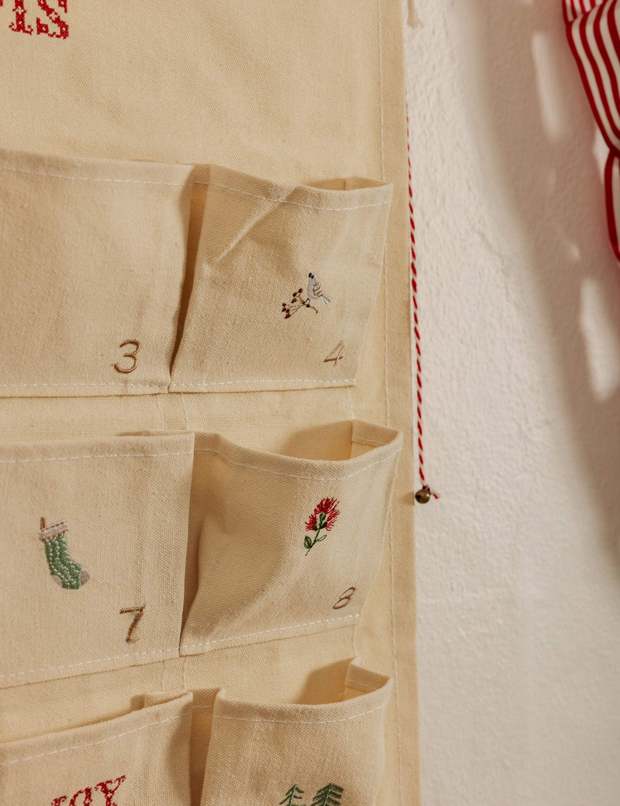 Personalized embroidered advent calendar with vintage cross stitch designs on cotton canvas pockets
