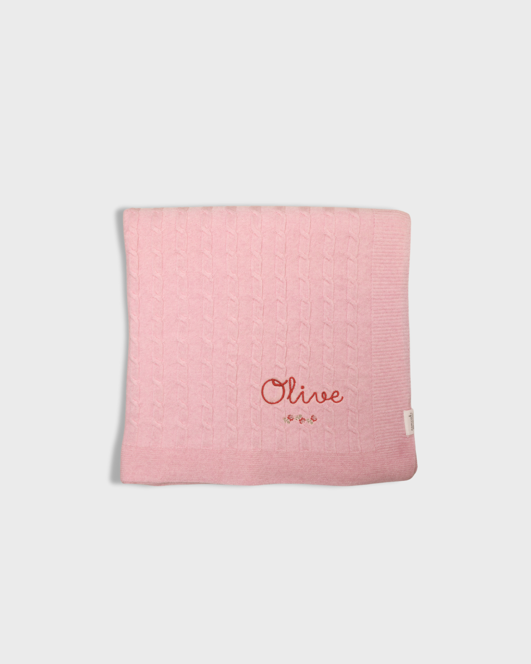 Pink merino baby blanket with rosette cross stitch embroidery and personalized name Olive