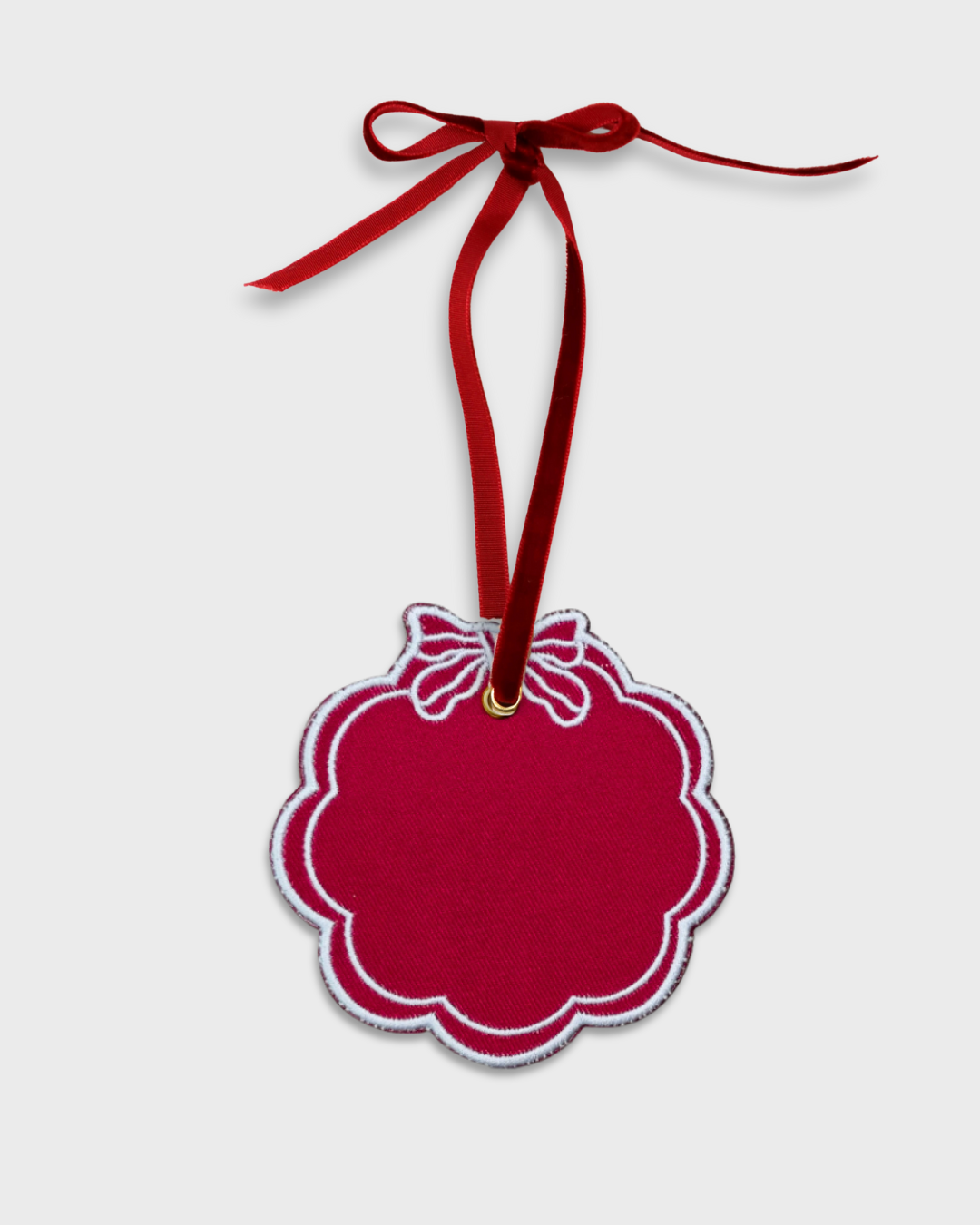 Red scalloped initials ornament with white embroidery and red velvet ribbon for hanging, 10cm x 10cm.
