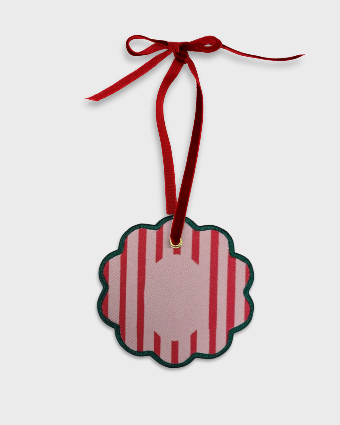 Personalised initials ornament with red stripes and green scalloped edge hanging on red velvet ribbon