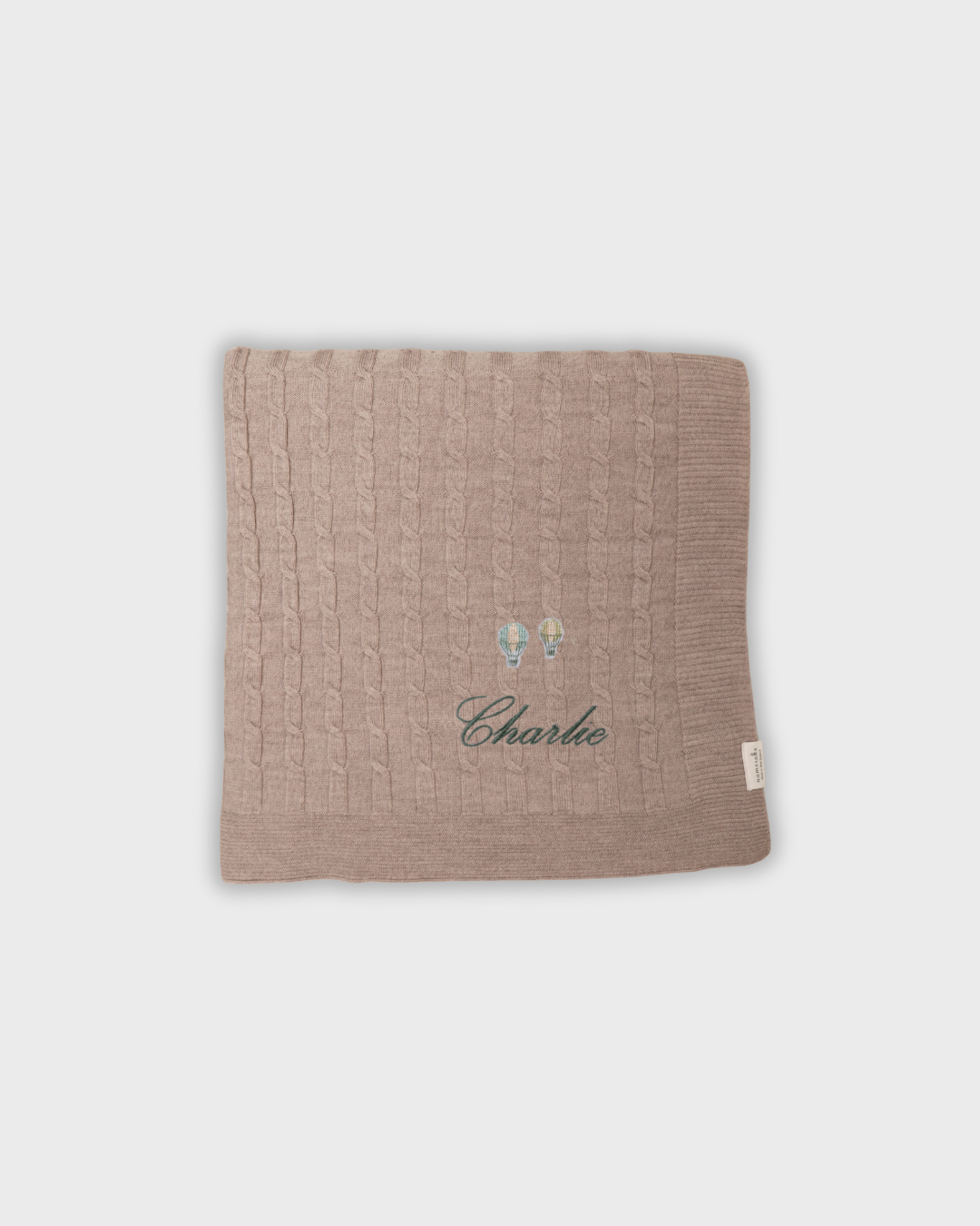 Merino baby blanket with embroidered hot air balloons and personalized name Charlie in soft wool fibers