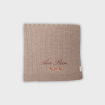 Soft Merino baby blanket with personalized rosette embroidery and cable knit design