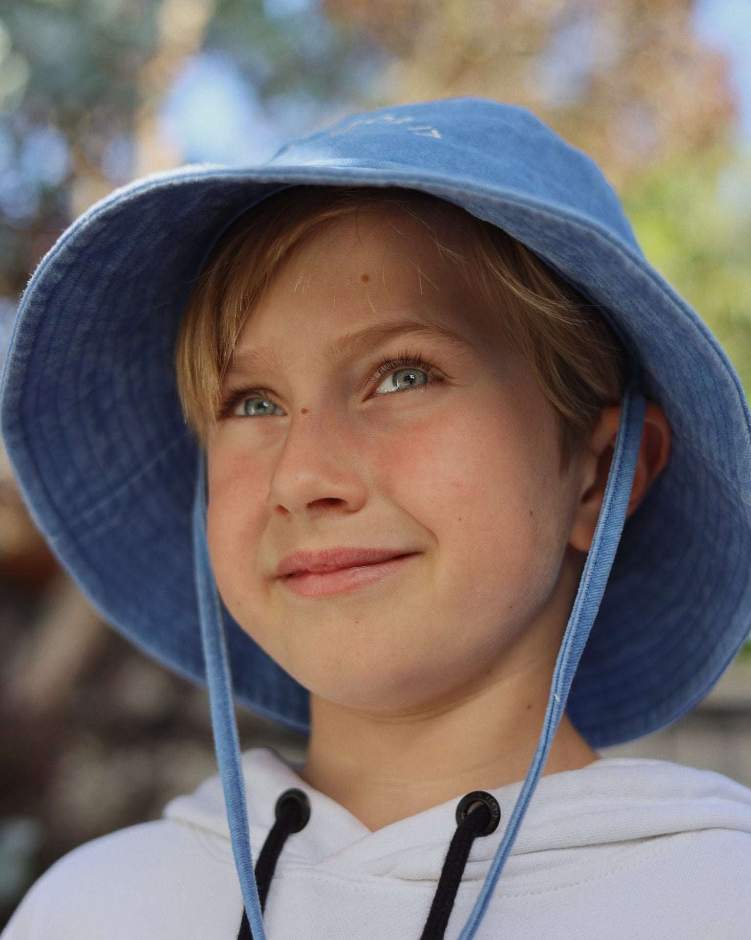 Customised bucket hat made of 100% washed cotton worn by a child, suitable for personalisation and embroidery.
